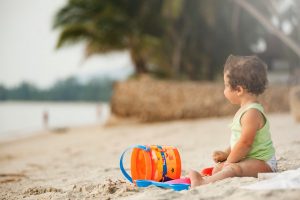 baby mit buddeleimer am strand