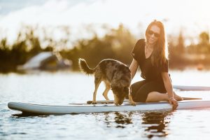 Frau mit Hund auf SUP